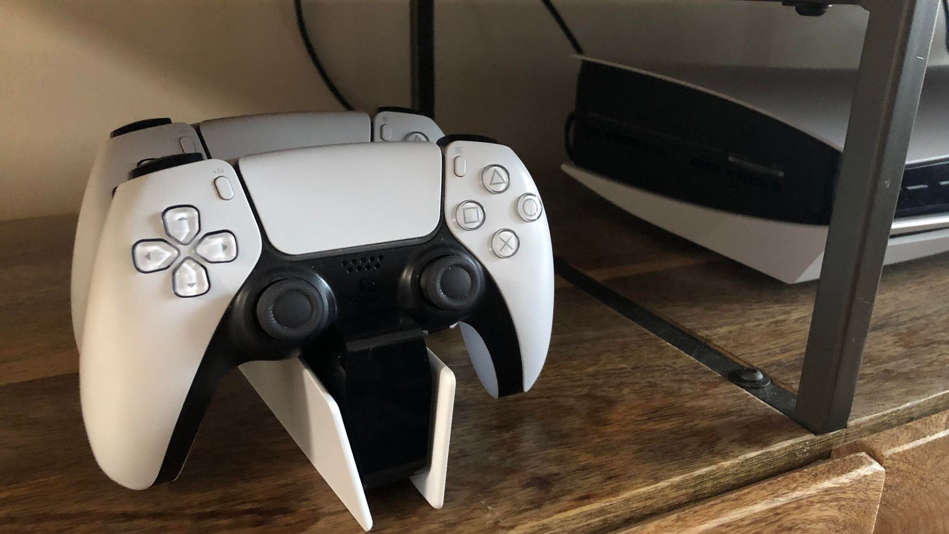 A shot of the PlayStation DualSense Charging Station next to a PlayStation 5