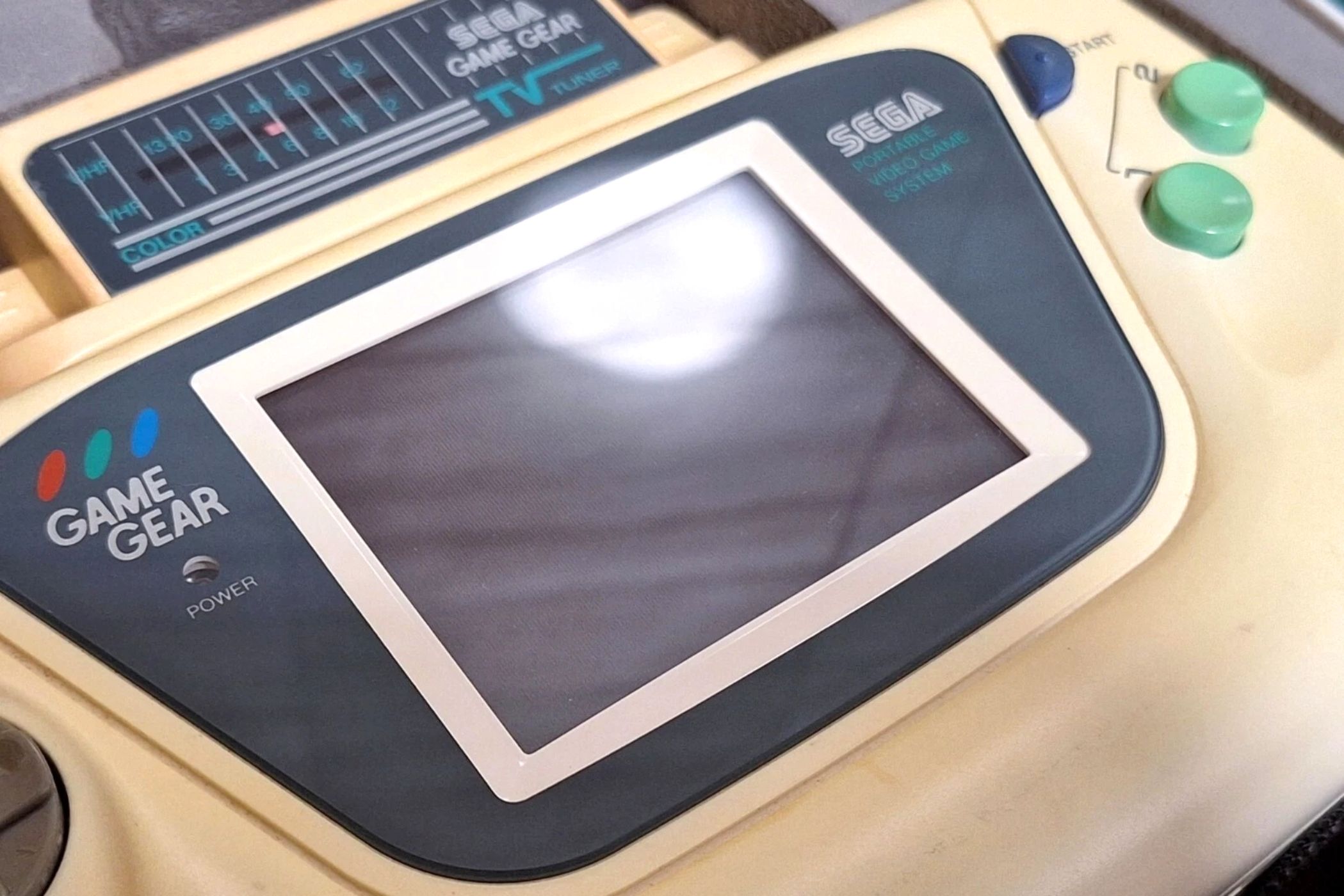 A close-up of a Sega Game Gear white edition.