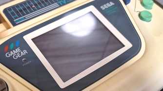 A close-up of a Sega Game Gear white edition.