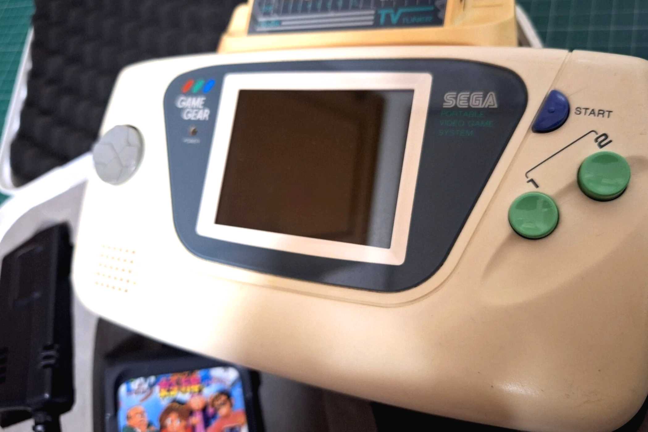 A close-up of a Sega Game Gear white edition.