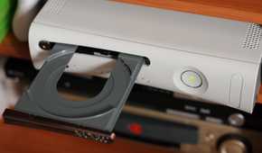 The disc tray of the Xbox 360 open.
