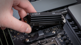 Person installing Crucial T700 2TB Gen5 NVMe M.2 SSD with Heatsink