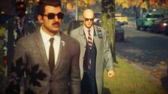Agent 47 stalking a guard in the suburbs in Hitman: World of Assassination.