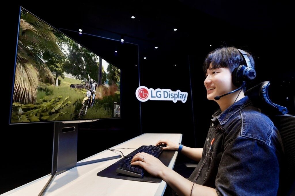 A person playing a game on an OLED monitor next to an LG Display logo