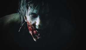 A close-up of a bloodied zombie face in Resident Evil 2 remake.