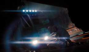 A monstrous creature standing in front of a crashed truck's headlights in SCP: Fragmented Minds.