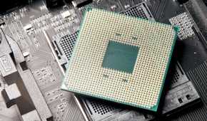 A CPU resting on a motherboard socket with the CPU pins visible
