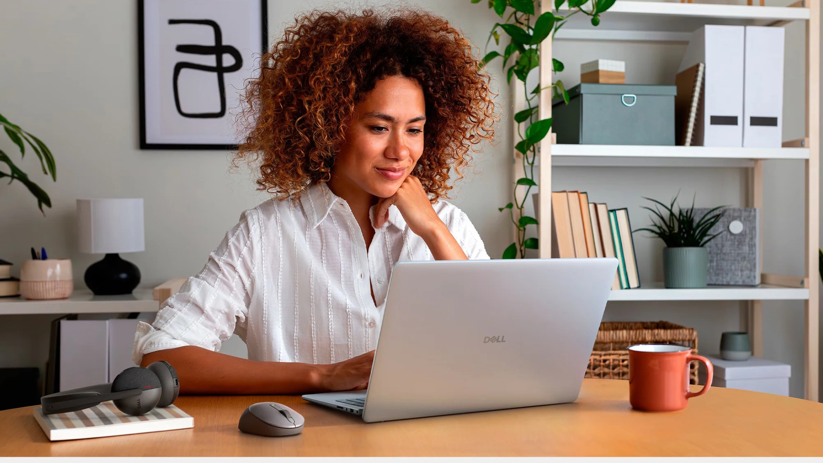 Persona que utiliza una computadora portátil Dell de 16 pulgadas en un escritorio