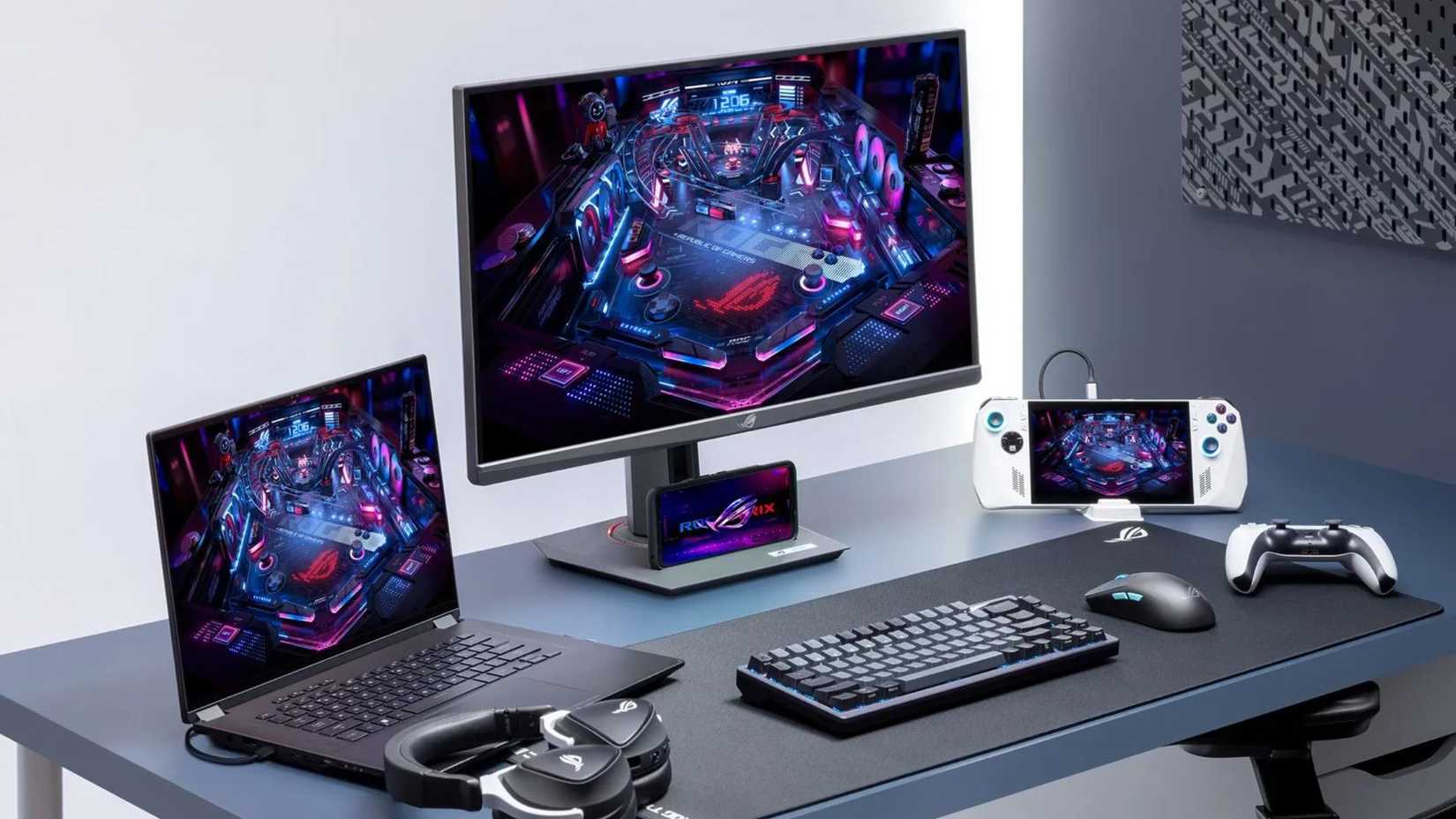 Asus XG279CNS monitor on desk next to laptop and gaming console