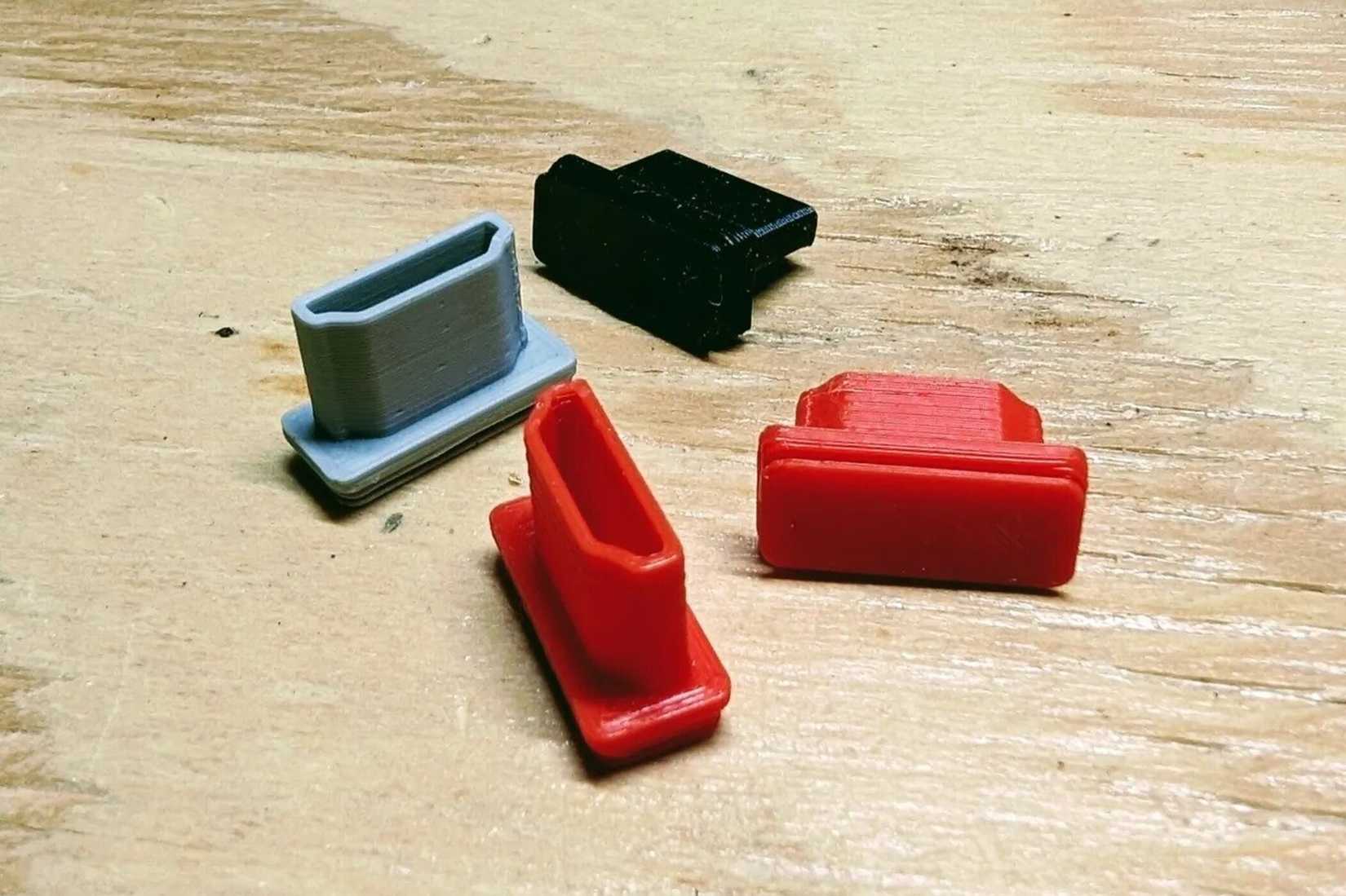 3D printed HDMI dust caps on a wooden surface