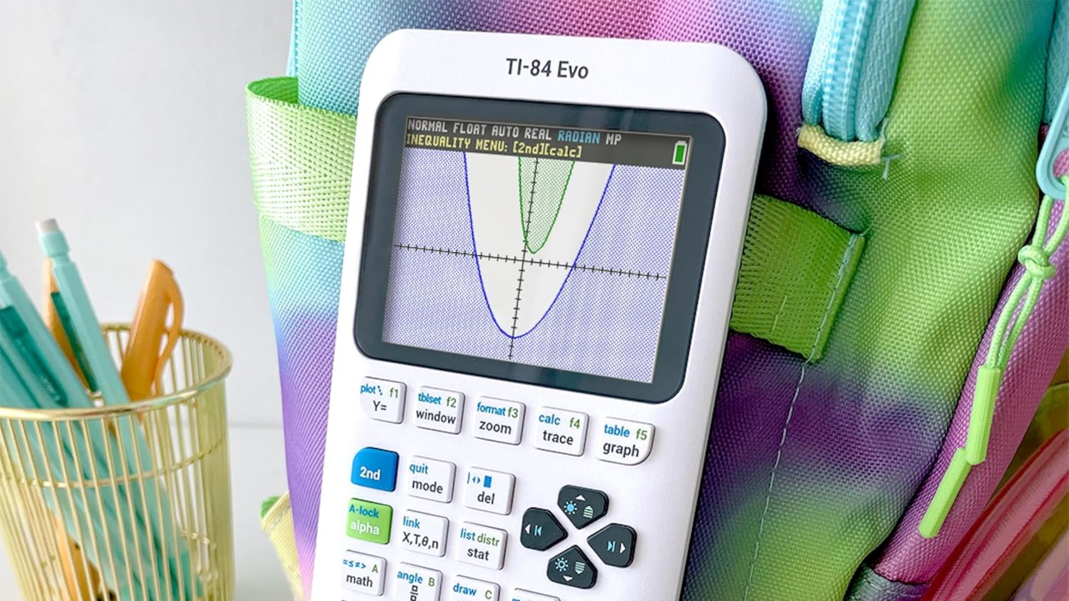 TI-84 Evo Graphing Calculator on backpack and near pens