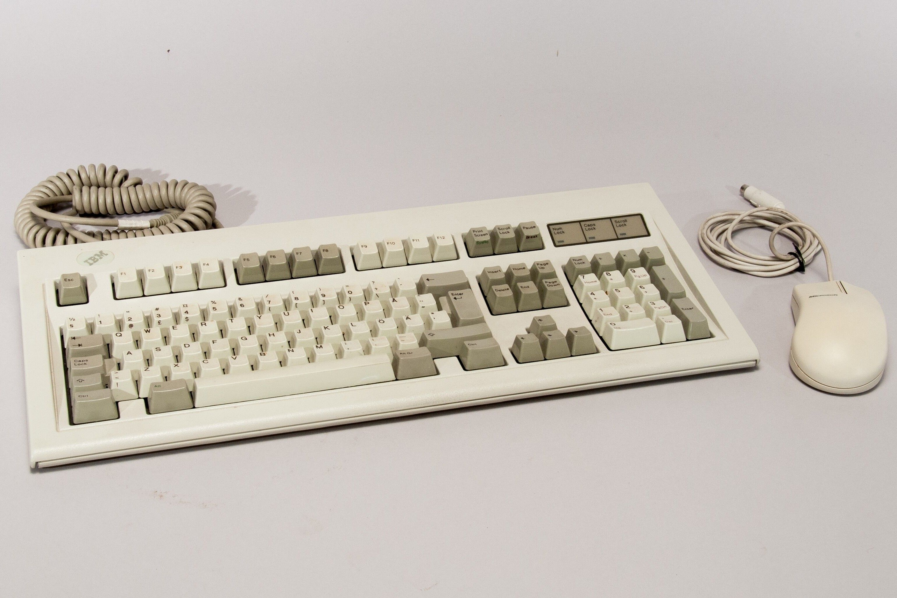 Retro keyboard and mouse on a white surface