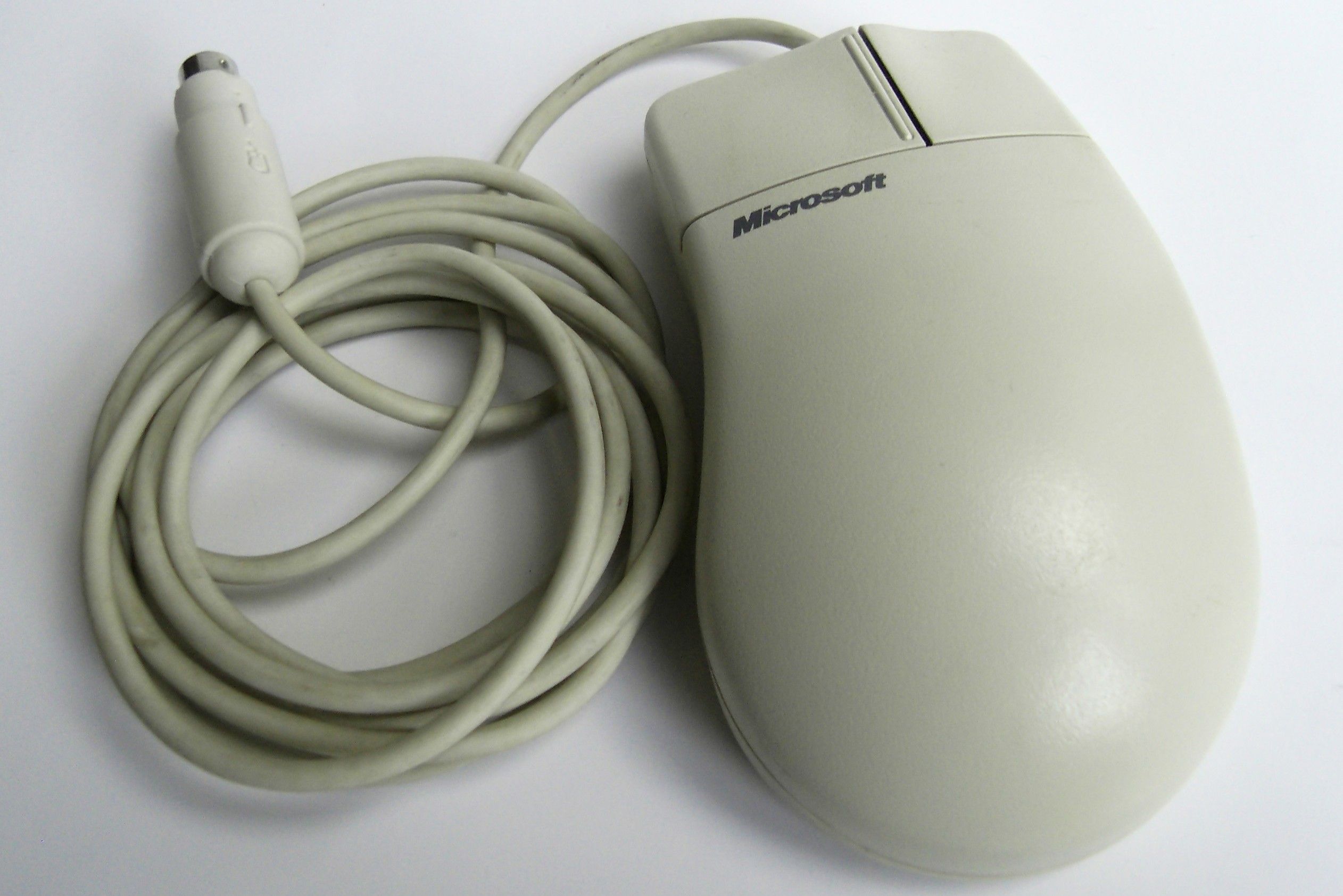 A white Microsoft mouse with a PS/2 cable