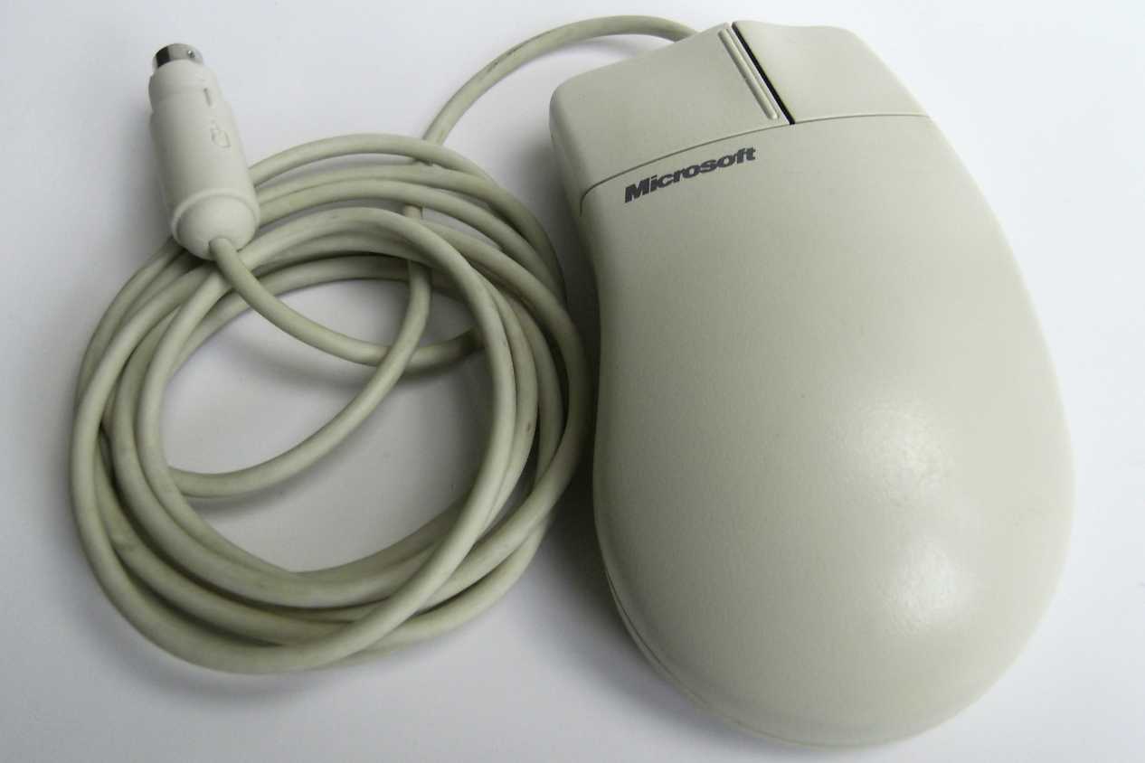 A white Microsoft mouse with a PS/2 cable