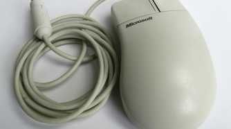 A white Microsoft mouse with a PS/2 cable