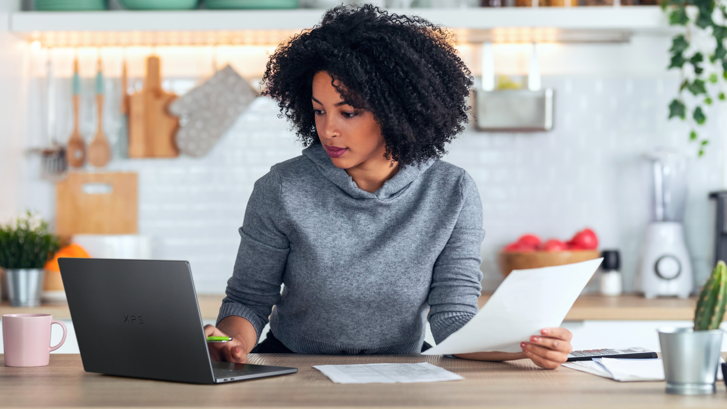 Woman working on the Dell XPS 14 in her kitchen