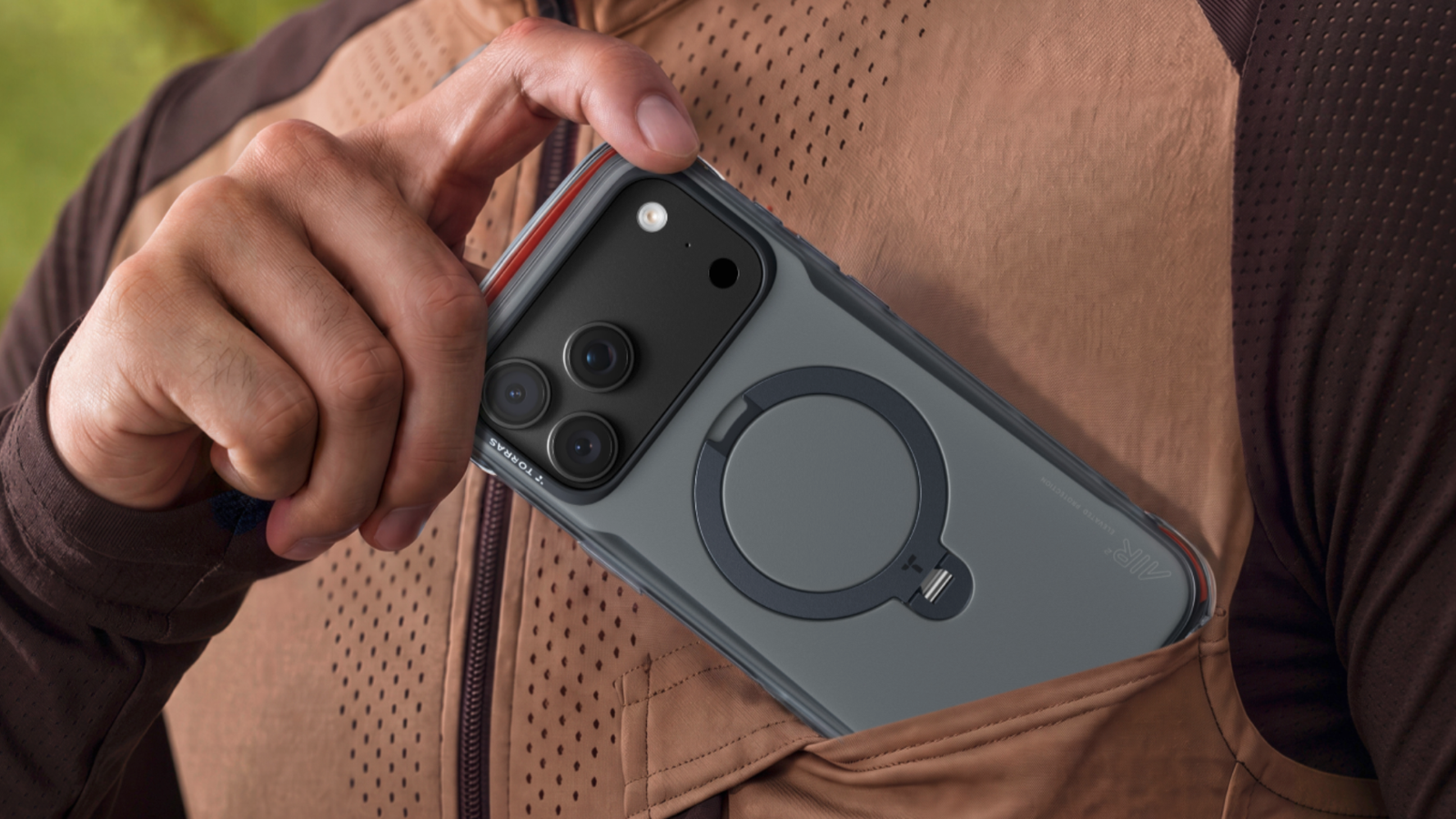TORRAS анонсировала серию защитных чехлов Ostand Q3 для линейки iPhone 18 Pro Смартфон в защитном сером чехле с магнитным кольцом-подставкой убирают в карман куртки