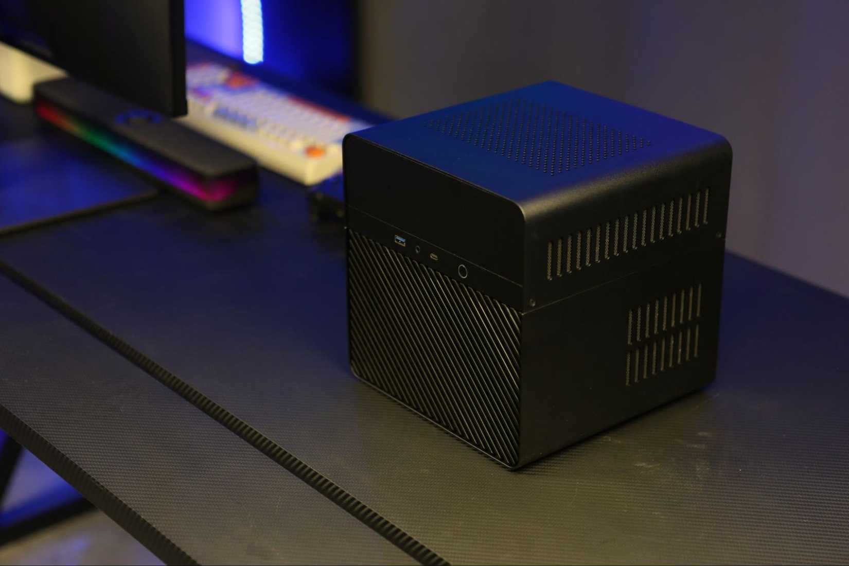 An elevated three-quarters view of the Cephalon Locy on a desk next to a monitor and keyboard.