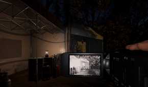 Screenshot from Phasmophobia video game of player character shooting video of the exterior or a building