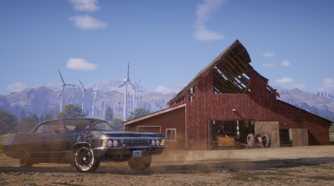 A blue car in front of a red barn