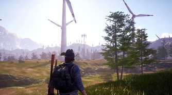 A man walking towards a field of wind turbines