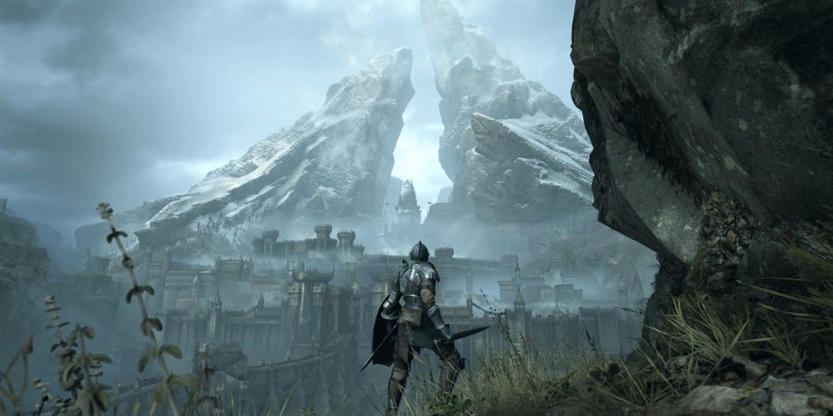 demon souls overlooking a castle with a big mountain behind it