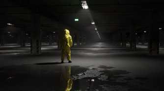 A man in a hazmat suit in a dark underground parking lot