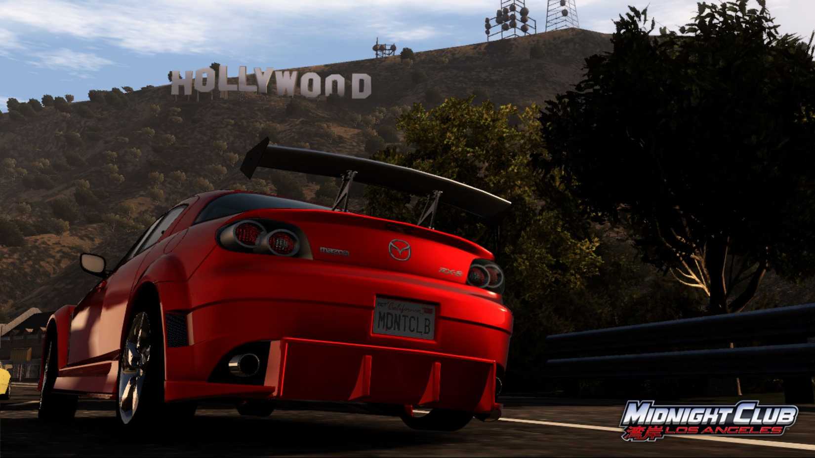 Screenshot from Midnight Club: Los Angeles of orange Mazda on road with the Hollywood sign in the background