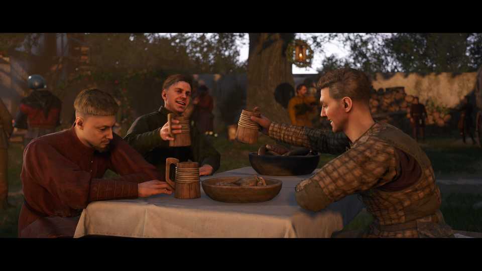 Screenshot from Kingdom Come: Deliverance II video game of three men sitting around a table drinking and eating in medieval setting.