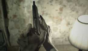 A screenshot of Ethan loading a gun in Resident Evil 7: Biohazard