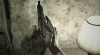 A screenshot of Ethan loading a gun in Resident Evil 7: Biohazard