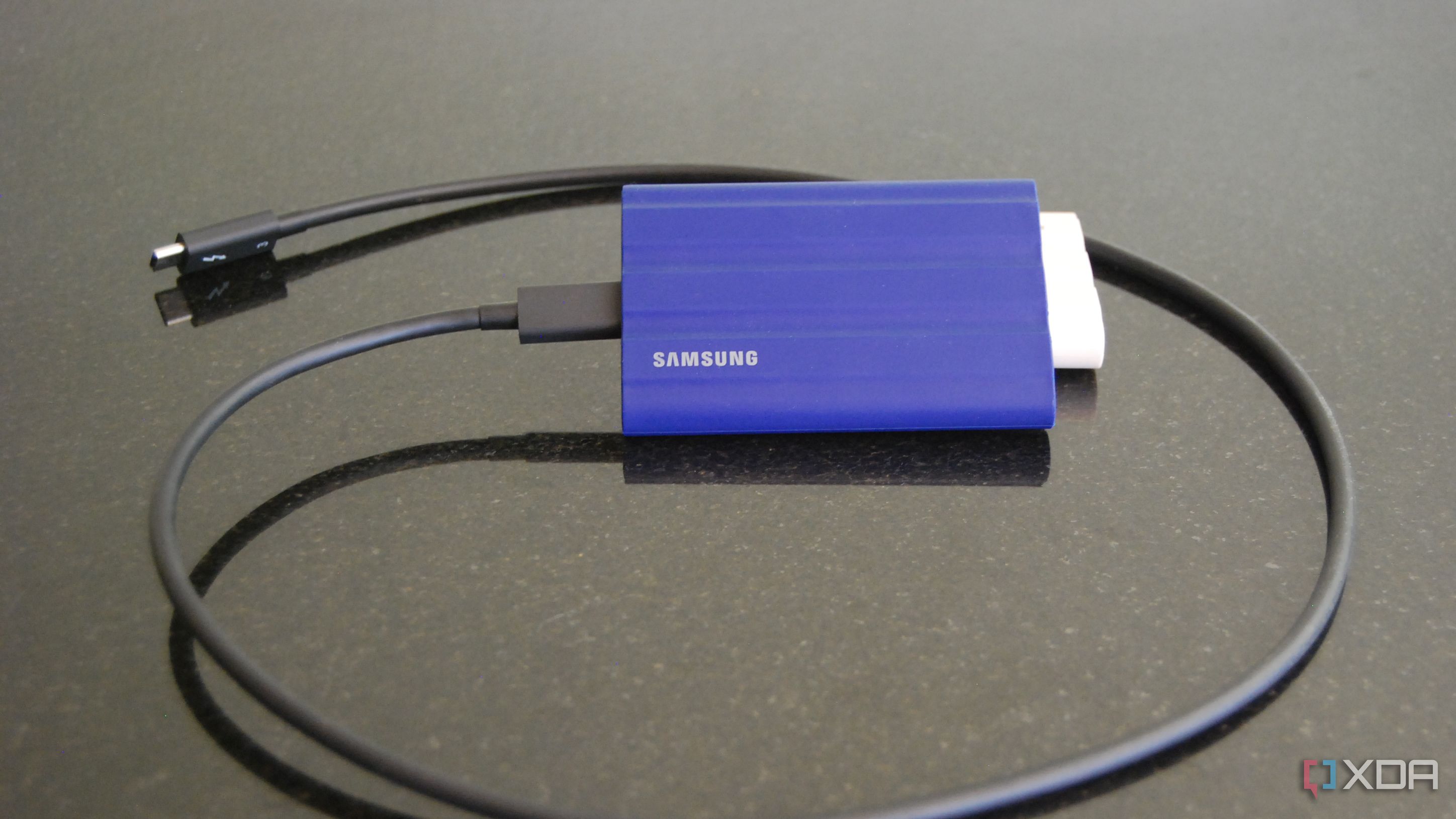 Samsung T7 Shield portable SSD in blue with a USB C cable attached
