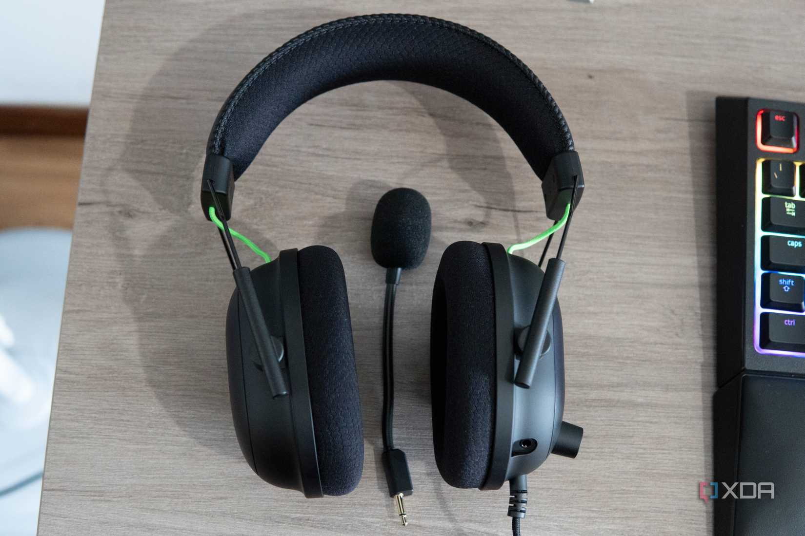A Razer BlackShark V2 headset with a detached microphone next to it