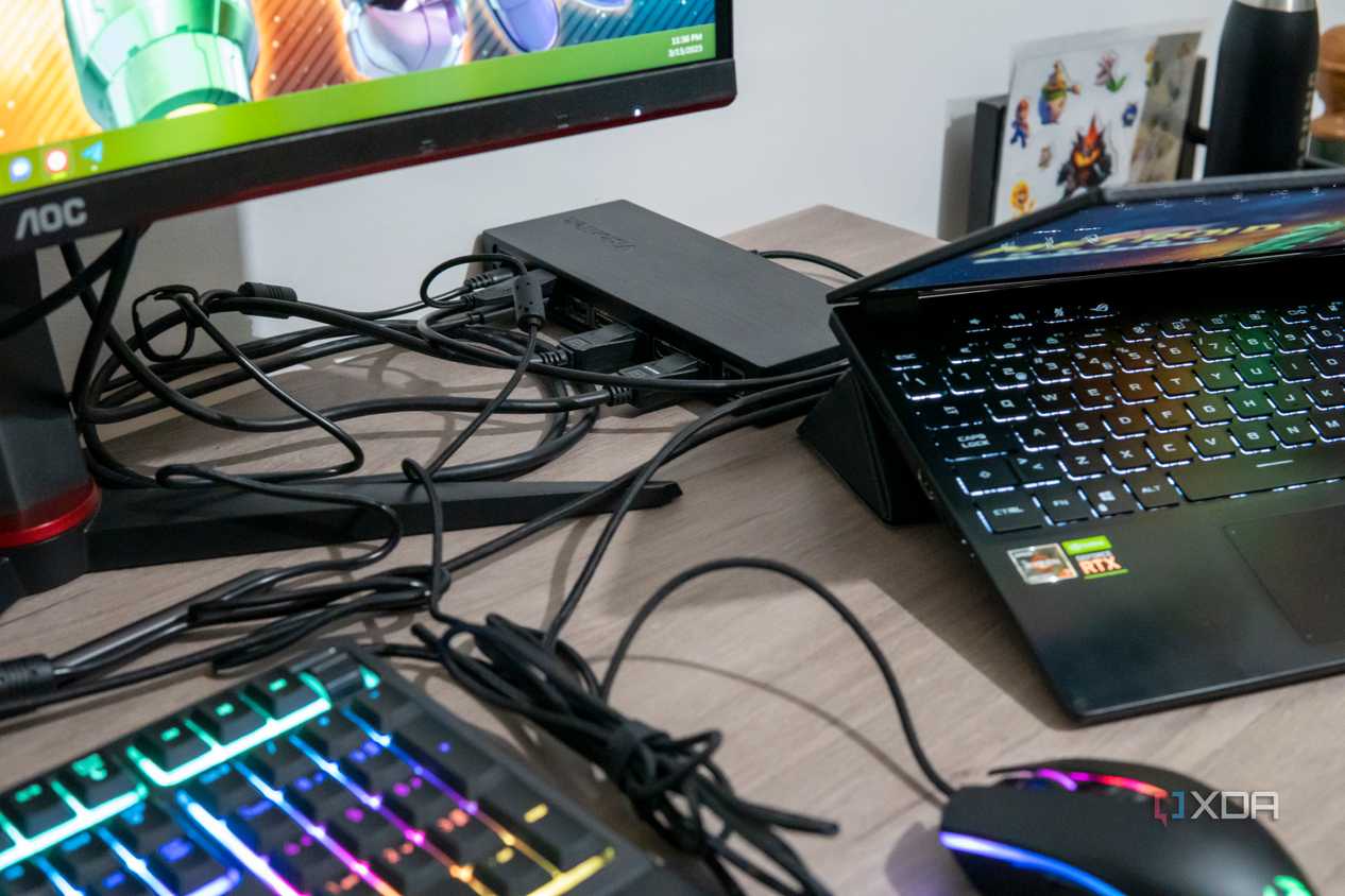 A VisionTek VT7400 docking station with a laptop and multiple peripherals around it