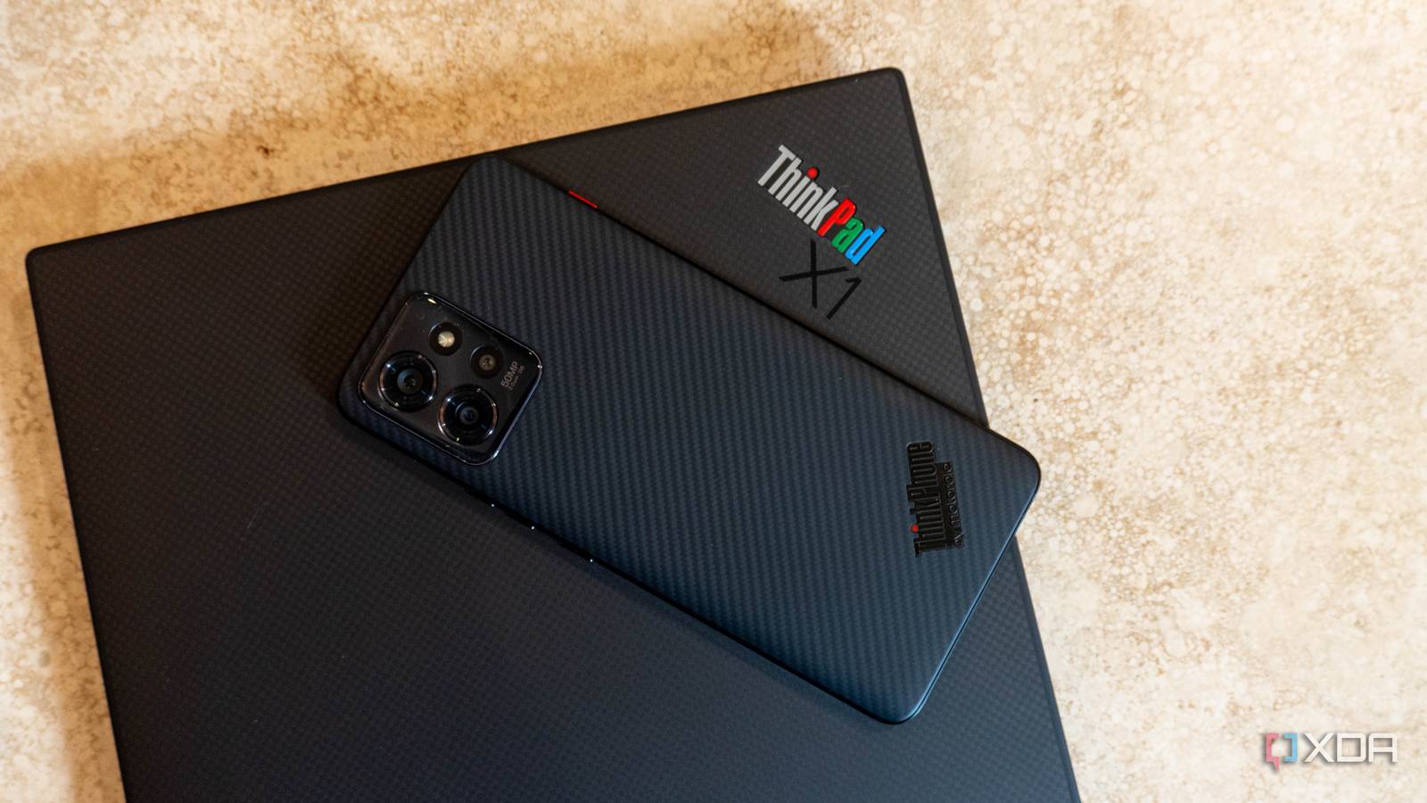 ThinkPhone on top of ThinkPad laptop with colorful ThinkPad X1 logo