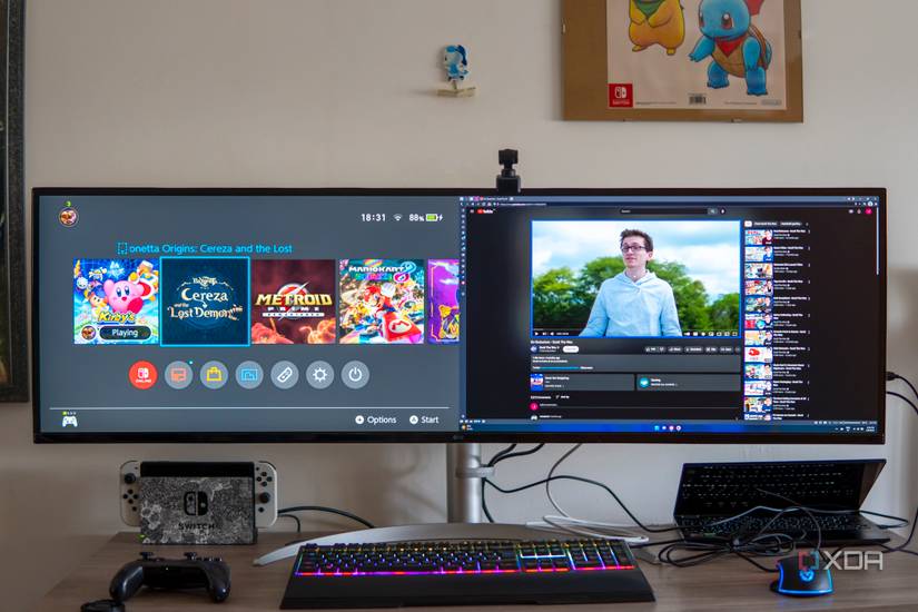 A desk with an LG UltraWide 49W95C monitor connected to a laptop and a Nintendo Switch, both of which are displaying on the monitor simultaneously.