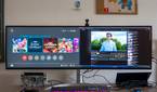 A desk with an LG UltraWide 49W95C monitor connected to a laptop and a Nintendo Switch, both of which are displaying on the monitor simultaneously.
