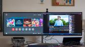 A desk with an LG UltraWide 49W95C monitor connected to a laptop and a Nintendo Switch, both of which are displaying on the monitor simultaneously.