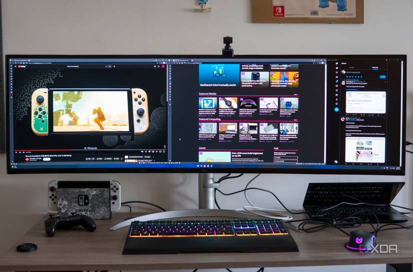 Front view of a desk with the LG UltraWide 49W95C monitor, a laptop, and various peripherals.