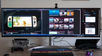 Front view of a desk with the LG UltraWide 49W95C monitor, a laptop, and various peripherals.
