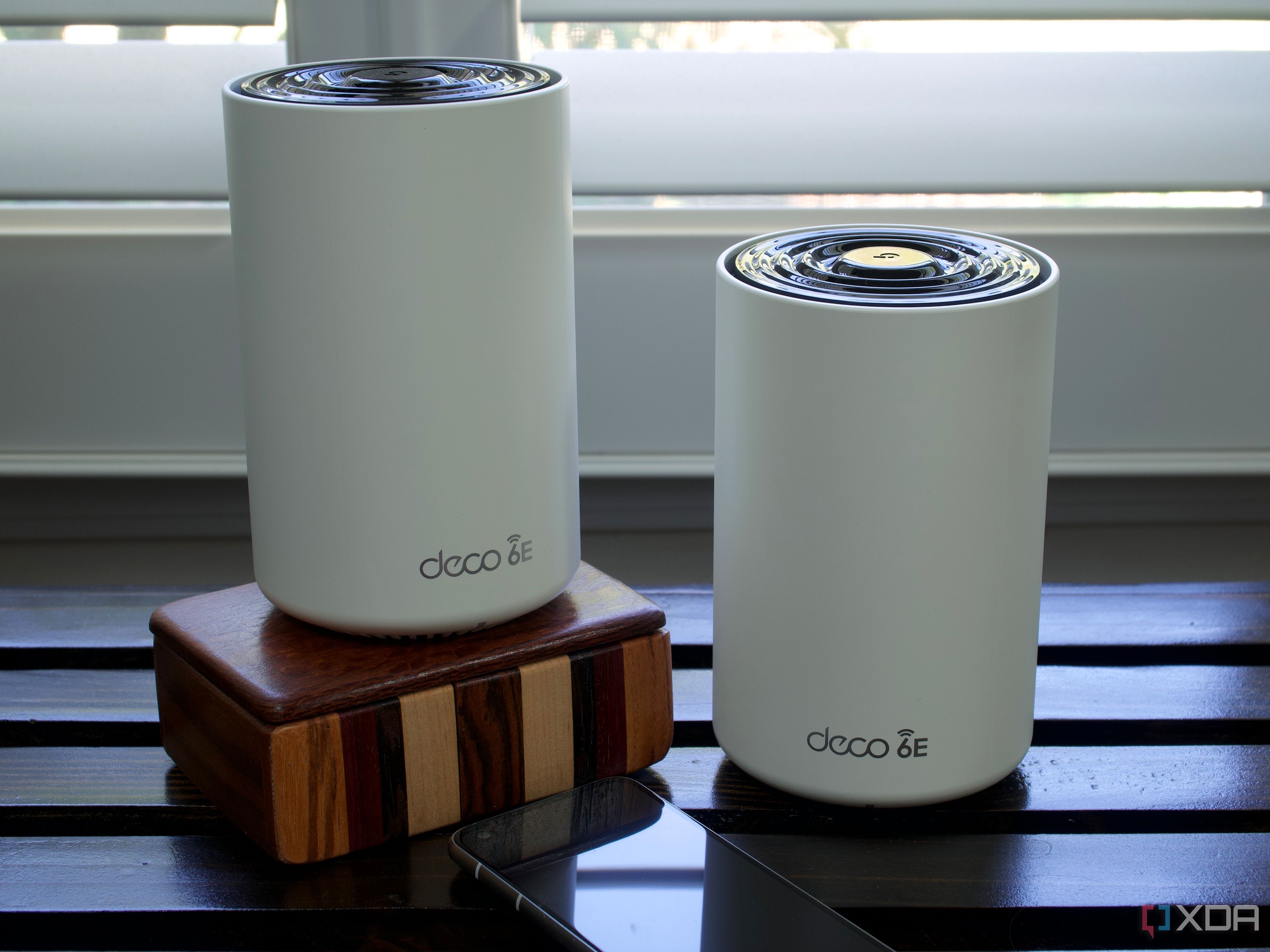 TP-Link Deco XE75 nodes on a wooden box