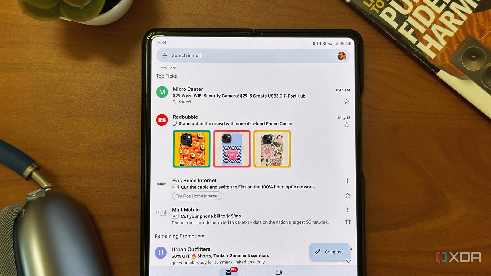 Gmail running on a Galaxy Z Fold 4 resting on a wooden desk.