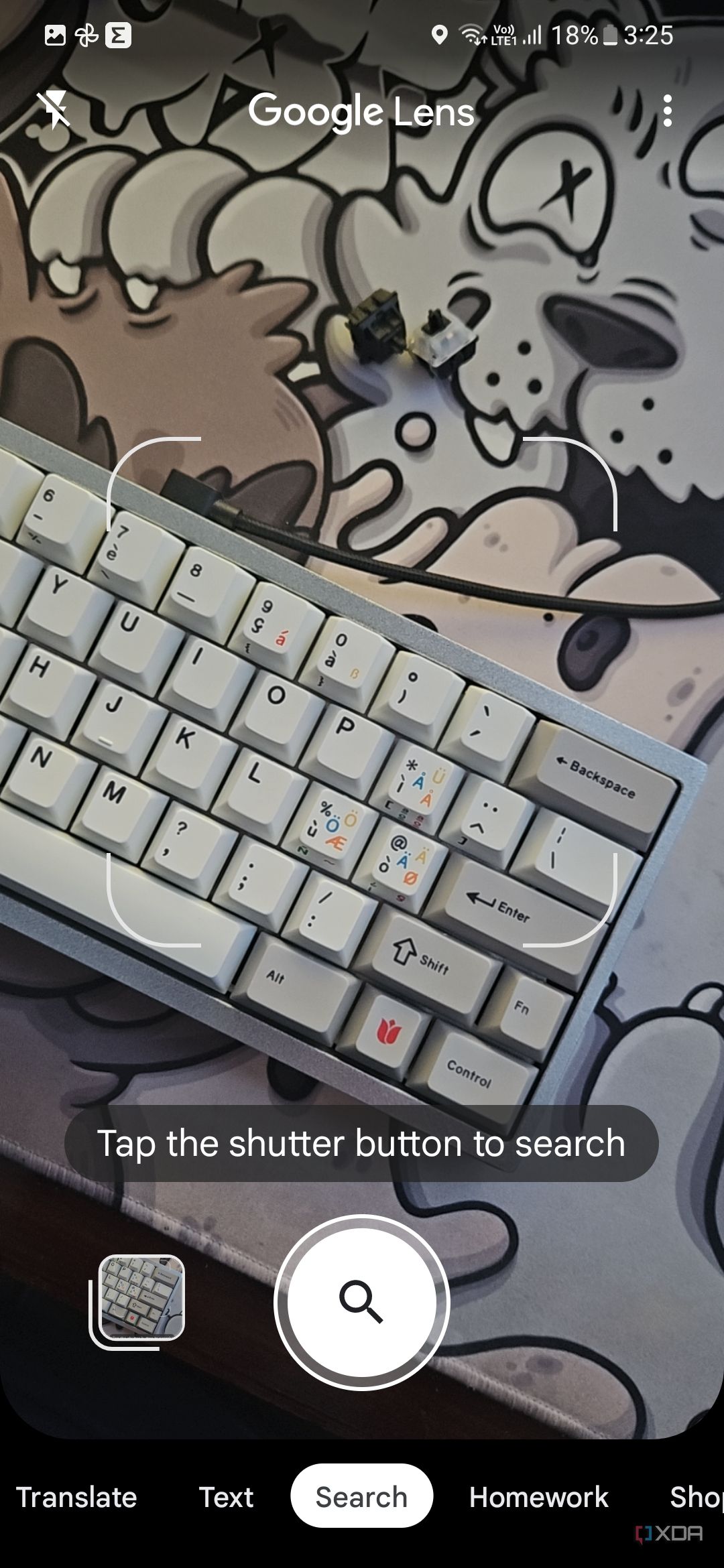 A screenshot showing the Google Lens viewfinder with a keyboard on a deskmat in frame.