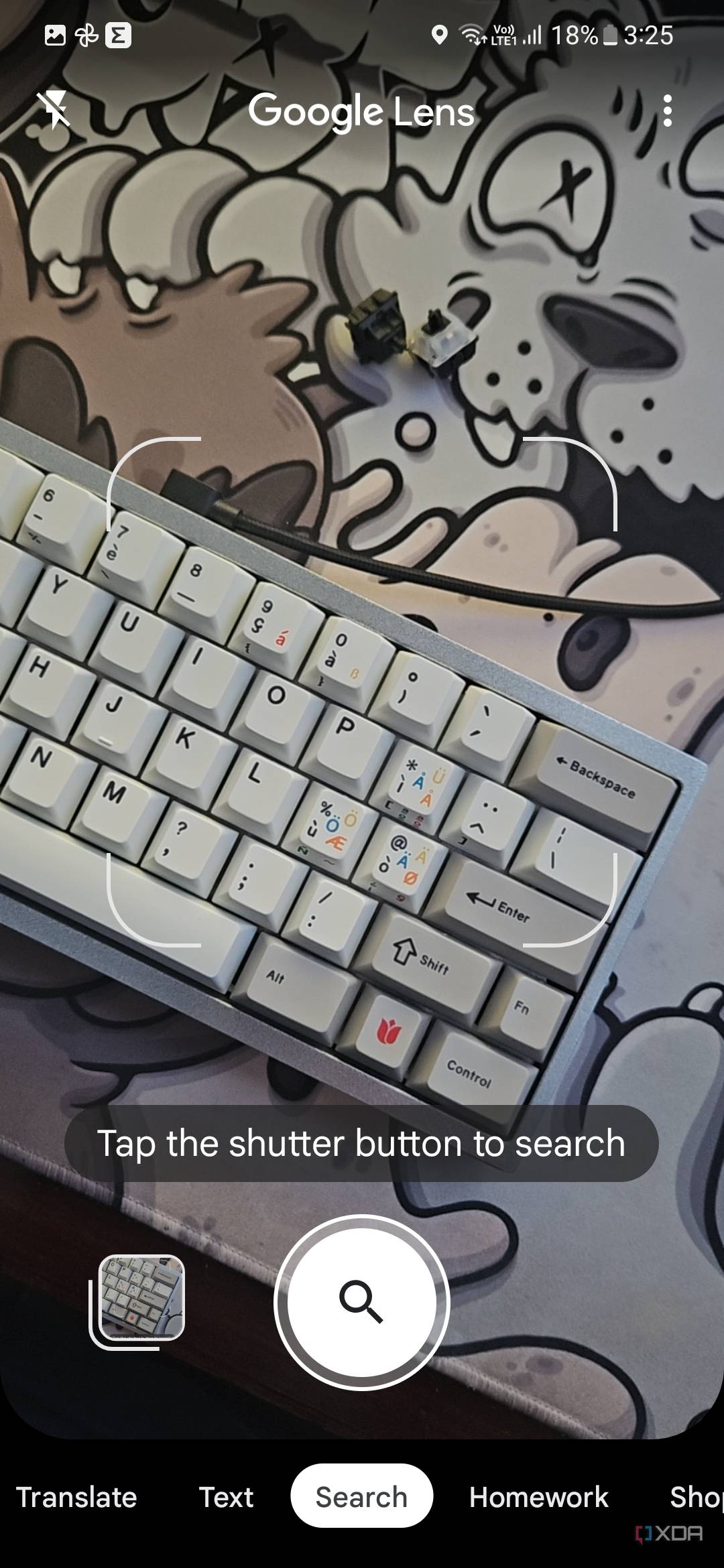 A screenshot showing the Google Lens viewfinder with a keyboard on a deskmat in frame.