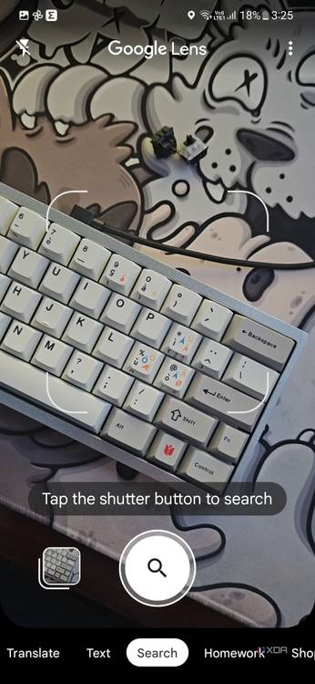 A screenshot showing the Google Lens viewfinder with a keyboard on a deskmat in frame.