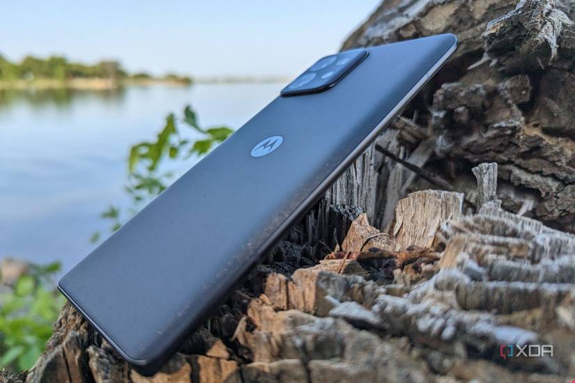 Motorola Edge+ 2023 leaning against a tree step showing the back and side of the phone