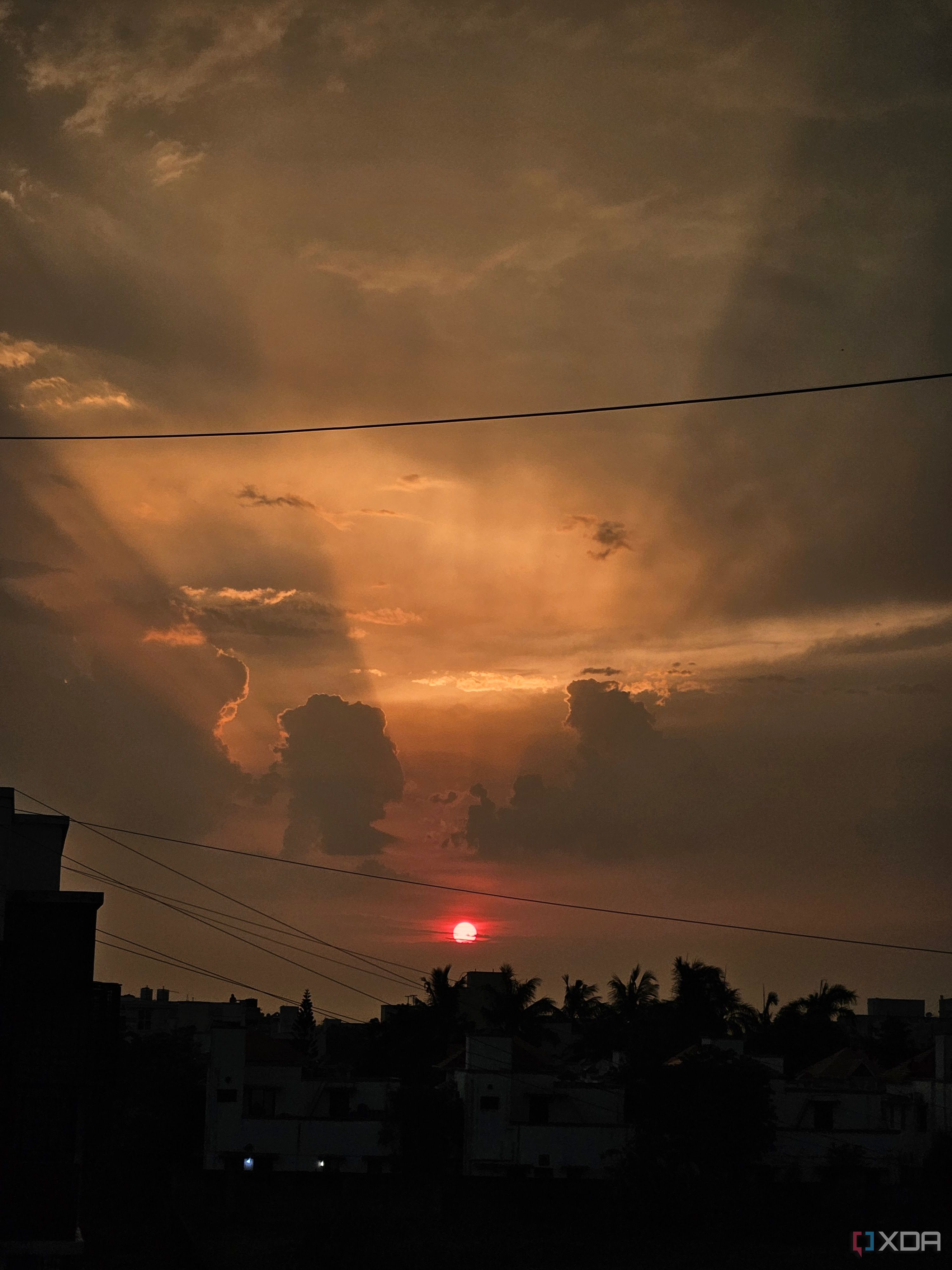 An image showing a sunset with its lights shining through the clouds.