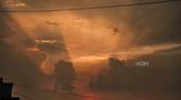 An image showing a sunset with its lights shining through the clouds.