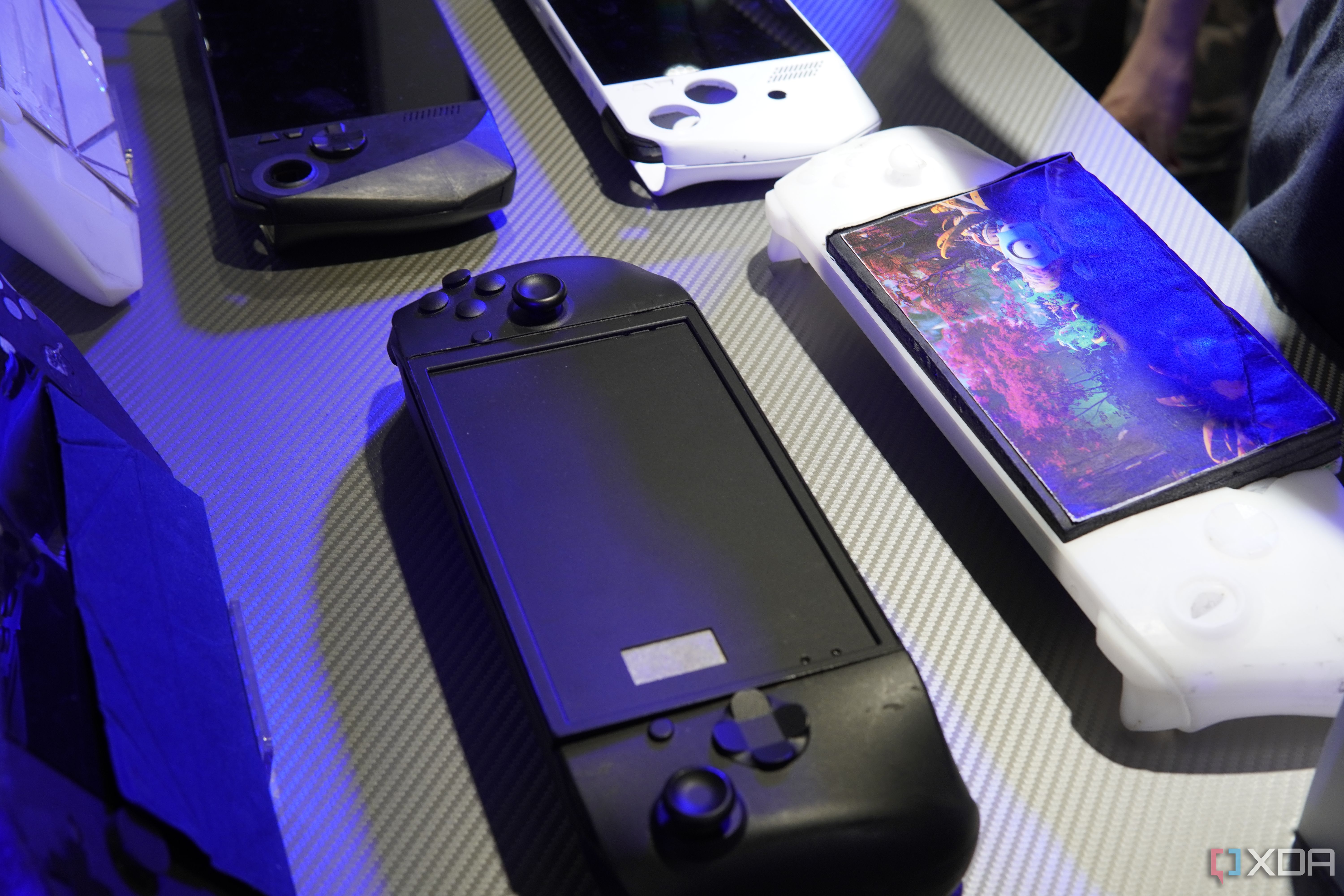 Prototype designs of the Asus ROG Ally, with one black model and one model that resembled an Xbox controller with a screen in the middle