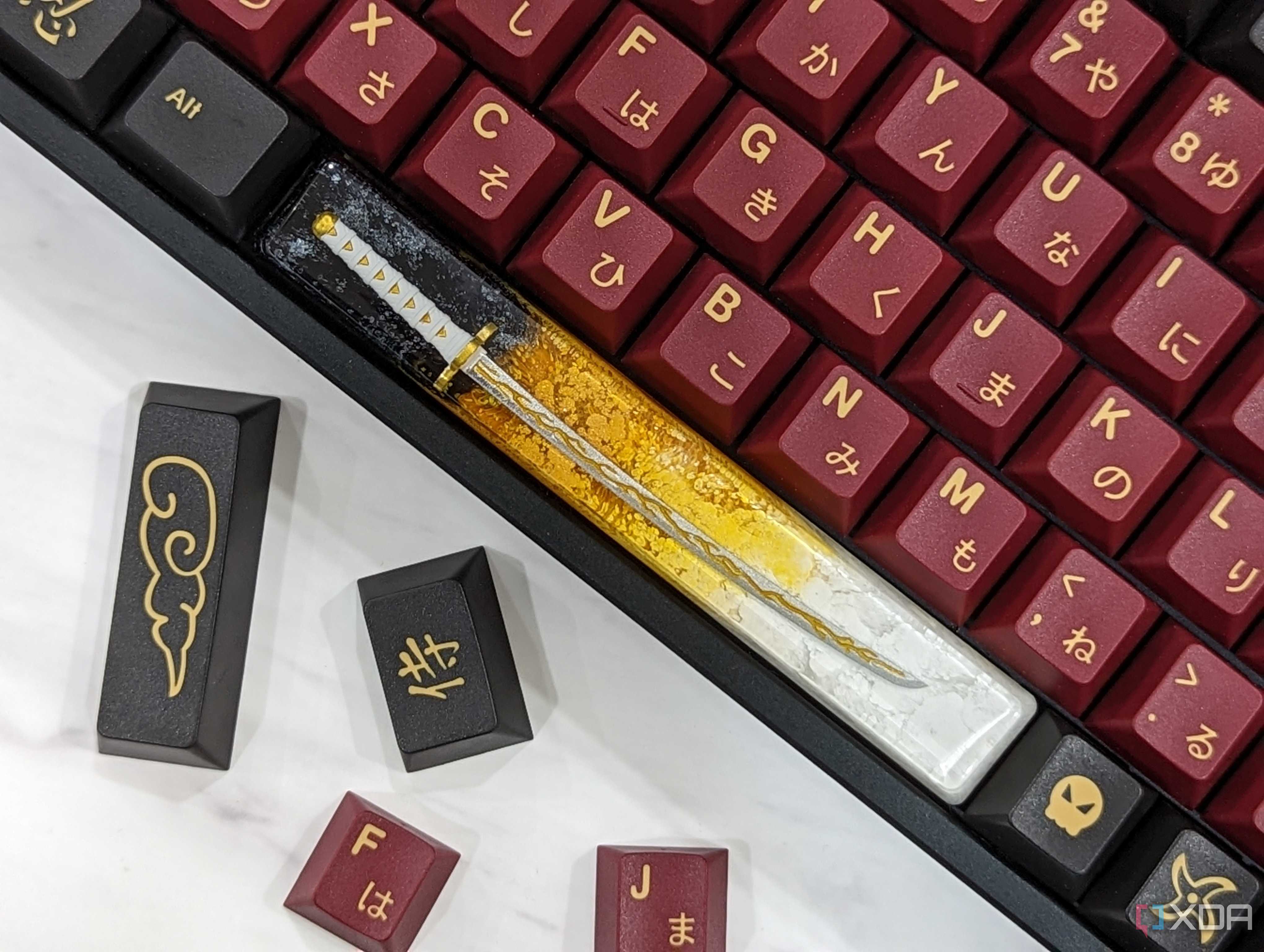 An image of a mechanical keyboard with GMK Red Samurai keycaps kept on a white marble.